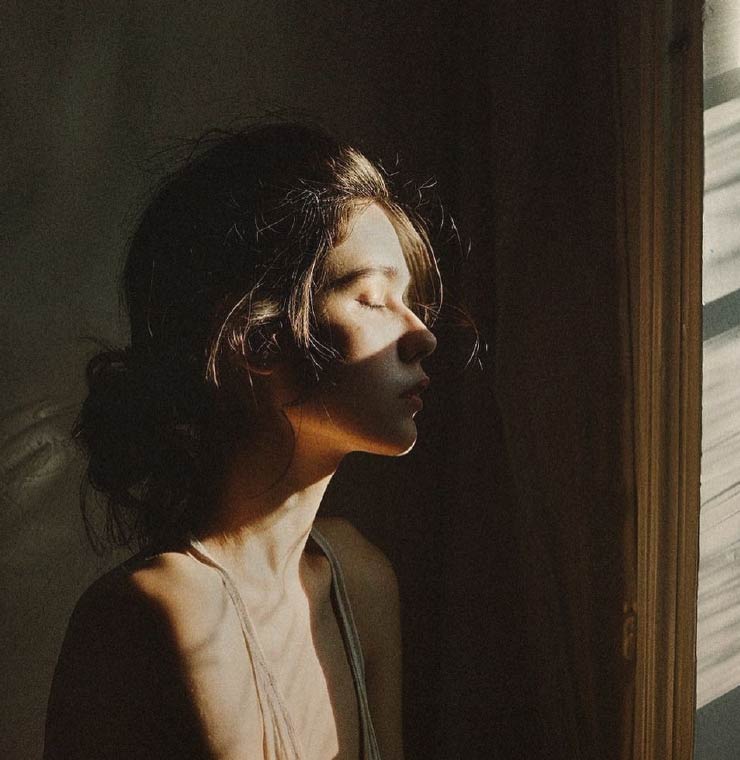 Mujer en contemplación con la luz del sol, evocando el camino interior del duelo